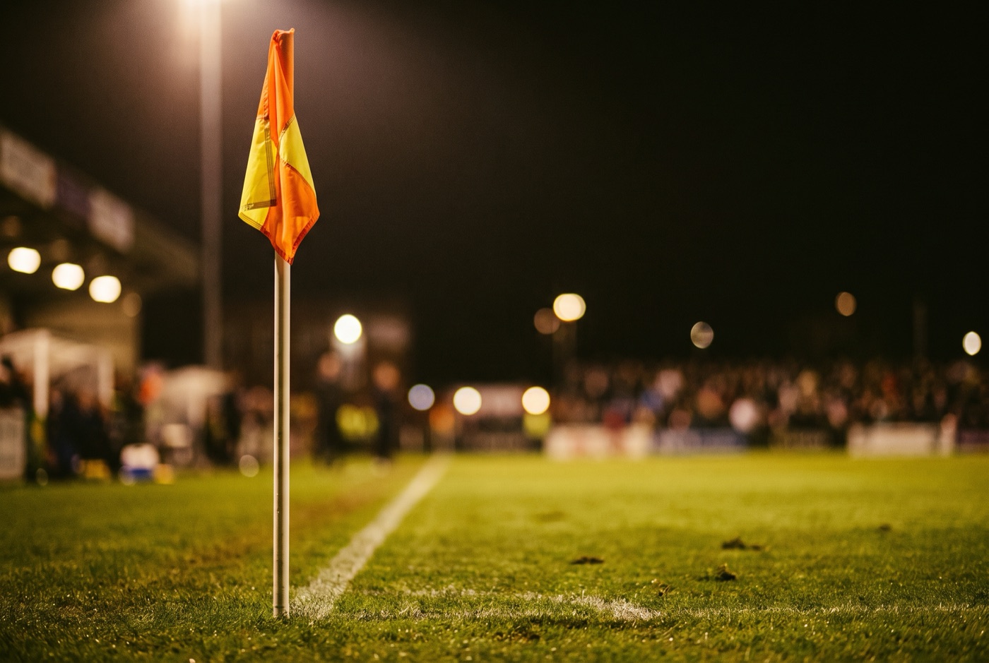 Banderín de córner en una cancha de futbol iluminada de noche